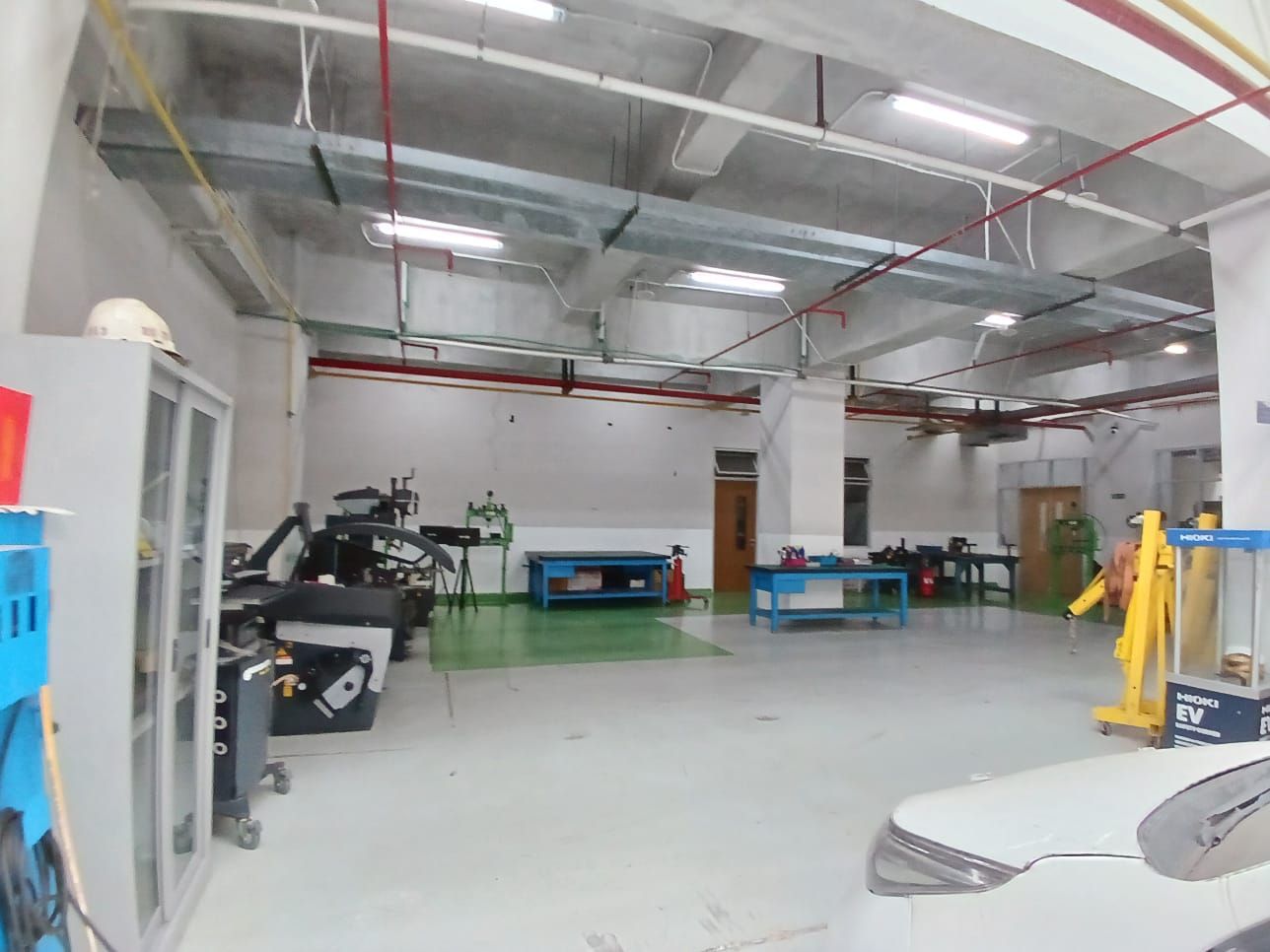 Main workshop floor with workbenches, presses and a Hioki EV station